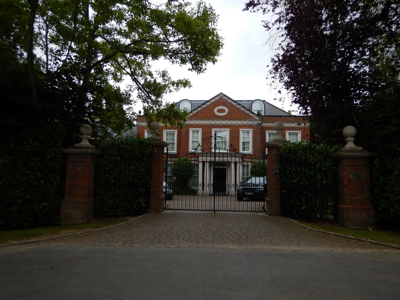 The entrance to a large detached house on a private road in Oxshott. Detached homes across Elmbridge averaged £1,593,107 in July 2026, up 3.7% in a year and the only property type gaining more than 3%